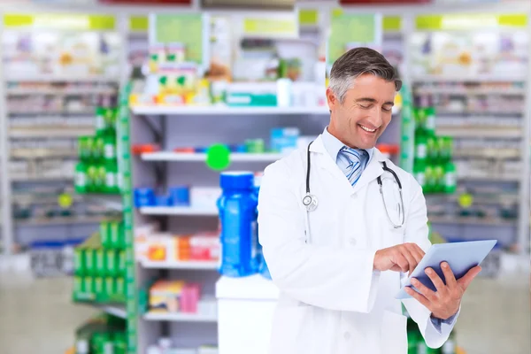 Composite image of happy doctor using tablet pc — Stock Photo, Image