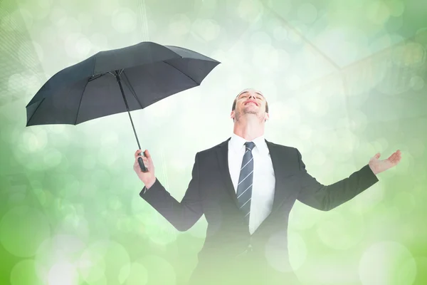 Uomo d'affari riparo sotto ombrello nero — Foto Stock