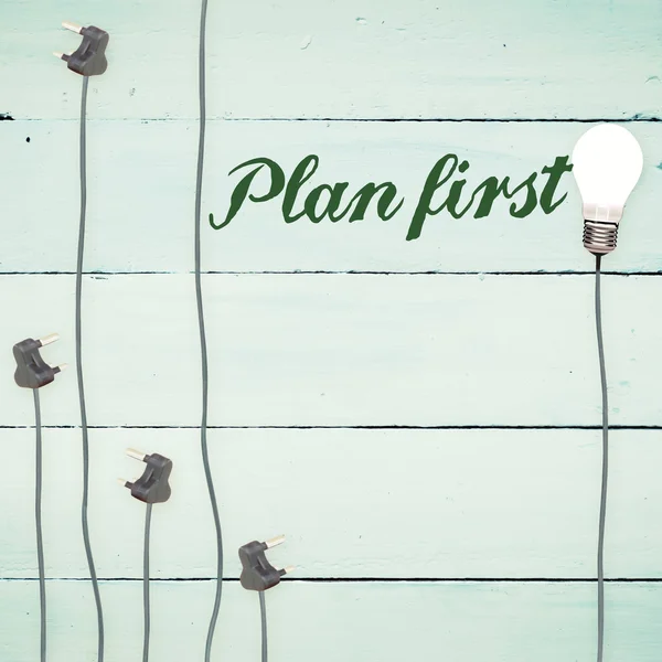 Plan first against light bulbs on wooden background — Stock Photo, Image