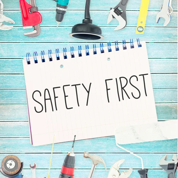 Safety first against tools and notepad on wooden background — Stock Photo, Image