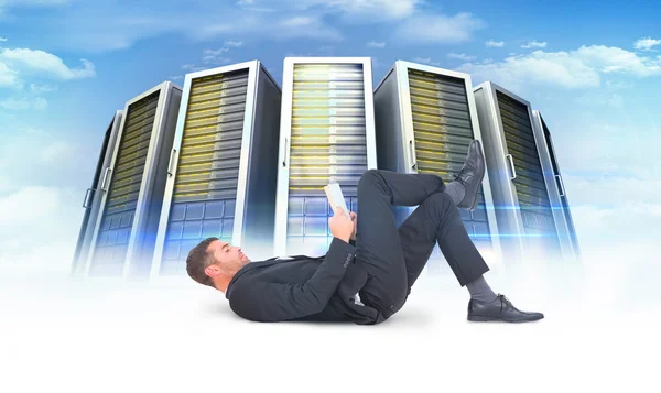 Businessman lying on floor reading book — Stock Photo, Image