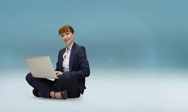 Composite image of businesswoman using laptop — Stock Photo, Image