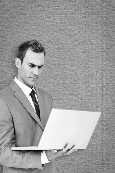 Composite image of businessman using laptop — Stock Photo, Image