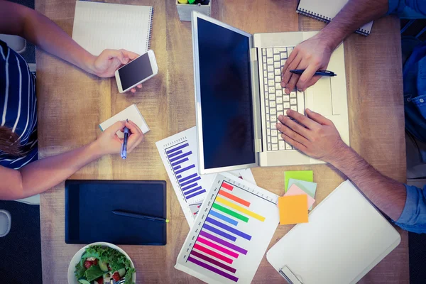 Creative workers sharing desk — 스톡 사진