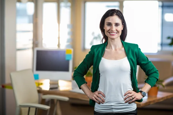 Glimlachend brunette staande handen op de heupen — Stockfoto