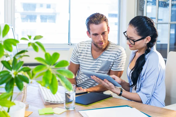 Smiling partners working together on tablet — Stockfoto