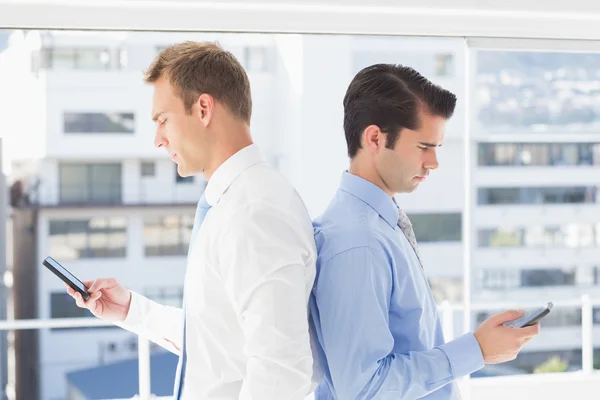 Two businessmen standing back to back — Stock Photo, Image