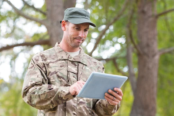 Soldado olhando para tablet pc no parque — Fotografia de Stock