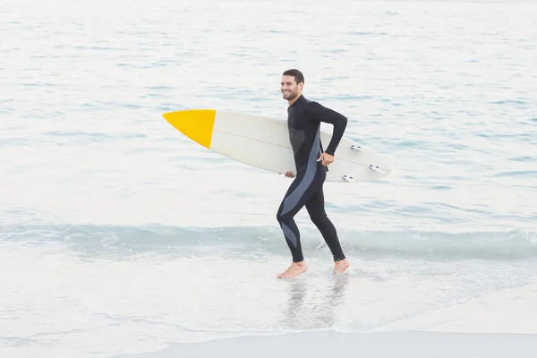 Muž v neopren s Surf Beach — Stock fotografie