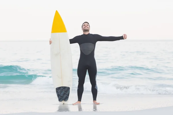 Bărbat în costum umed cu placă de surf pe plajă — Fotografie, imagine de stoc