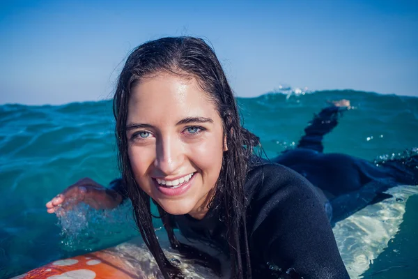 Mulher de fato de mergulho com prancha de surf na praia — Fotografia de Stock