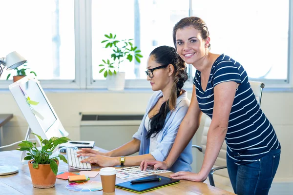 Smiling partners working together on computer — 图库照片