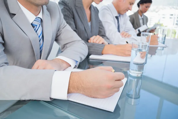 Business team taking notes during conference — Stock Photo, Image