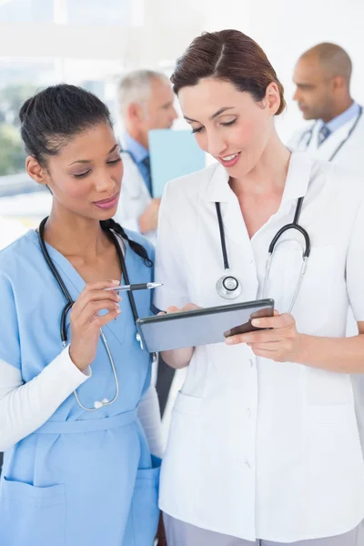 Médecins travaillant ensemble avec la tablette — Photo