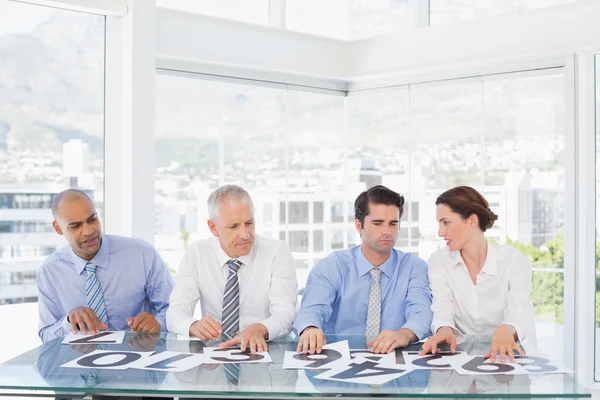 Concentrated business team sitting with their vote on the desk — Stock Photo, Image