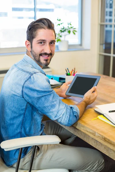 Casual businessman working at his desk with tablet — Stockfoto