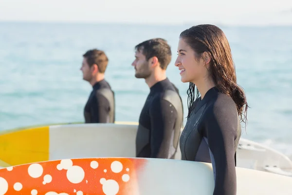 Amigos en trajes de neopreno con tabla de surf en la playa —  Fotos de Stock