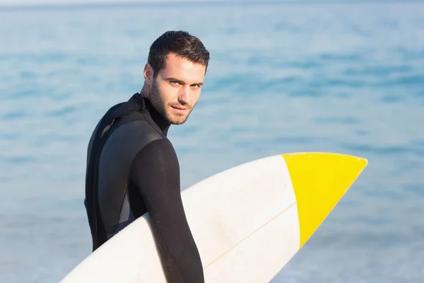 Mannen i våtdräkt med surfbräda på stranden — Stockfoto