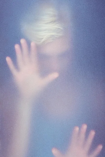 Mulher loira tocando vidro fosco — Fotografia de Stock