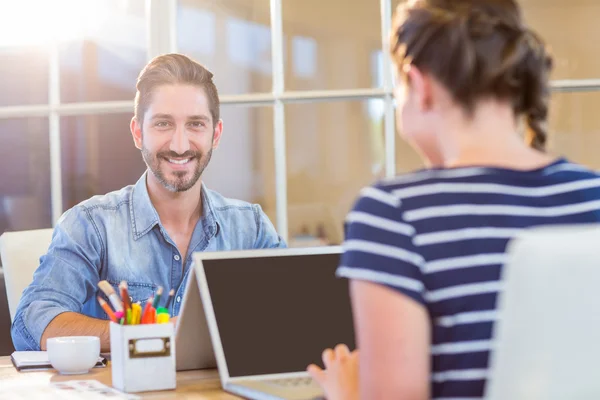 Lächelnde Kollegen arbeiten gemeinsam am Laptop — Stockfoto