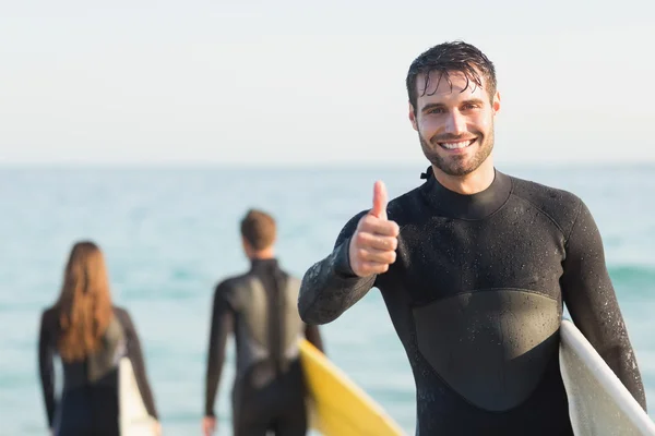 Amigos en trajes de neopreno con tabla de surf en la playa — Foto de Stock