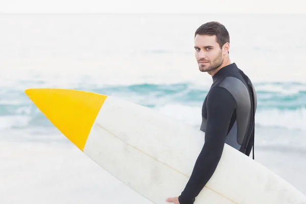 Mannen i våtdräkt med surfbräda på stranden — Stockfoto