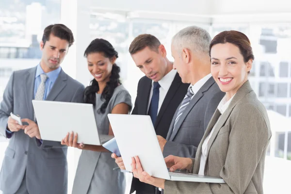 Colleghi di lavoro che mostrano i loro dispositivi multimediali ad ogni oth — Foto Stock