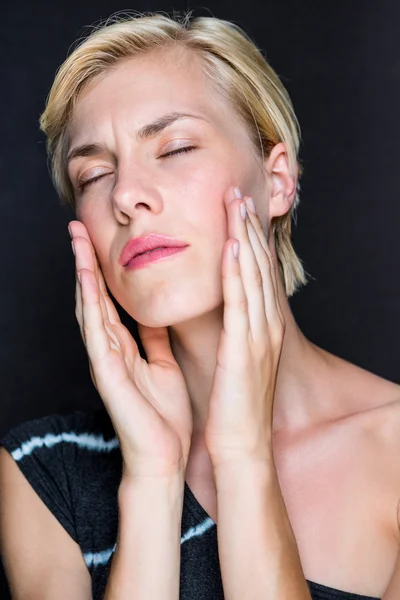 Attractive blonde woman touching her face — Stock Photo, Image