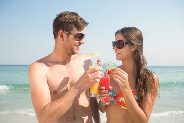 Couple drinking cocktails at beach — Stok fotoğraf