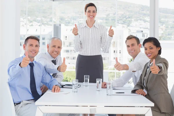 Equipe de negócios sorrindo para a câmera mostrando os polegares para cima — Fotografia de Stock