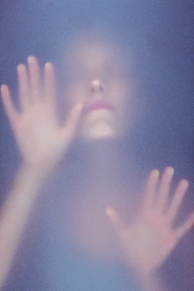 Mulher loira tocando vidro fosco — Fotografia de Stock