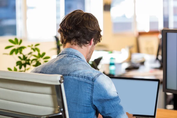 Casual businessman sitting at desk — Stock Photo, Image