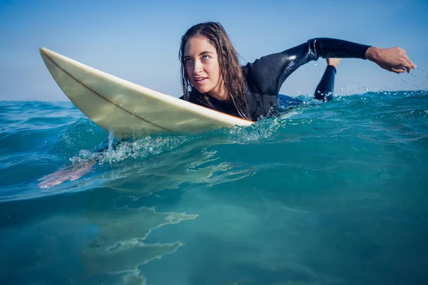 Donna in muta con tavola da surf in spiaggia — Foto Stock