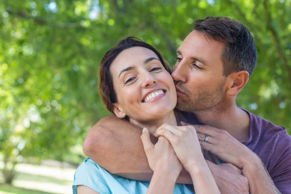 Glückliches Paar lächelt im Park in die Kamera — Stockfoto