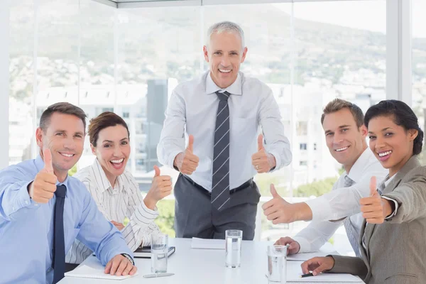 Business team smiling at camera showing thumbs up Royalty Free Stock Images
