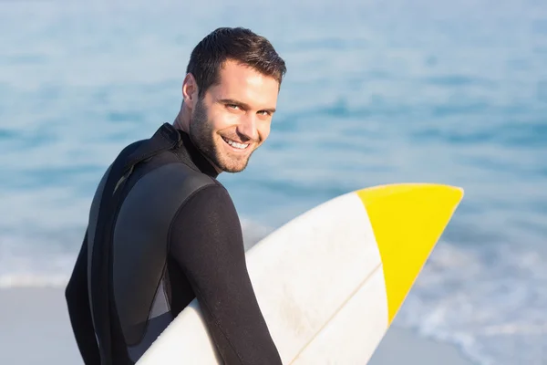 Mann im Neoprenanzug mit Surfbrett am Strand — Stockfoto