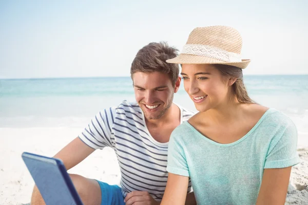 Casal usando tablet na praia — Fotografia de Stock