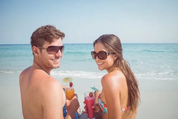 Couple drinking cocktails at beach — Stockfoto