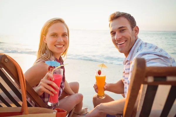 Couple drinking cocktails at beach — Zdjęcie stockowe