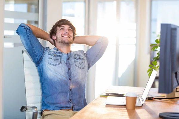 Sorrindo homem de negócios casual sentado na mesa — Fotografia de Stock