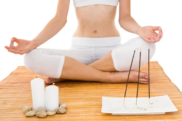 Fit woman meditating on bamboo mat — Stock Photo, Image