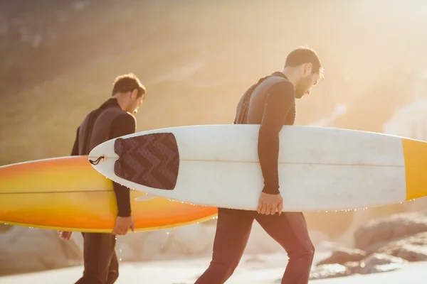 Men in wetsuits with surfboard at beach — Stock Photo, Image