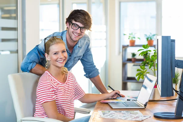 Smiling team working with digitizer and laptop — ストック写真