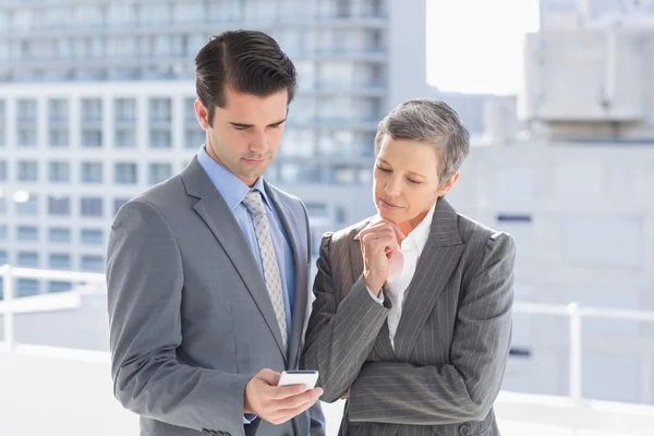 Business colleagues looking at phone — Stock Photo, Image