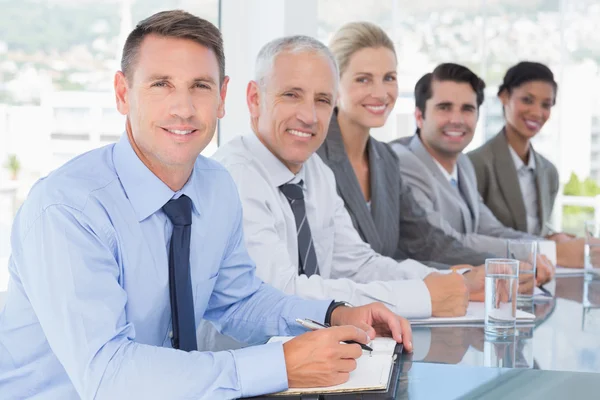 Geschäftsteam lächelt während Konferenz in die Kamera — Stockfoto