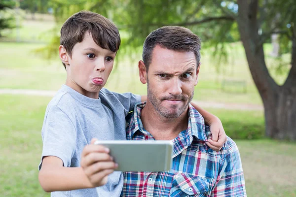 Father and son taking a selfie in park — Stok fotoğraf