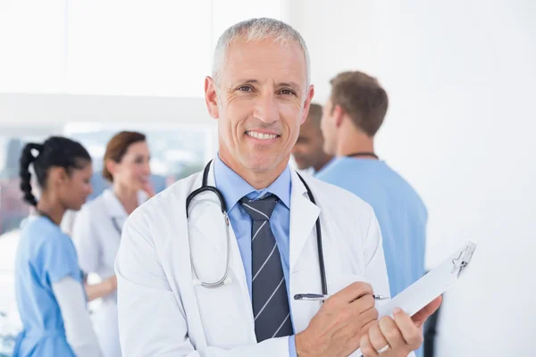 Médico masculino confiante sorrindo para a câmera — Fotografia de Stock