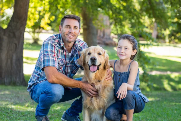 Отец и дочь с собакой в парке — стоковое фото