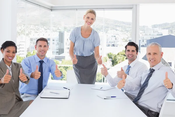 Business team smiling at camera showing thumbs up Stock Picture