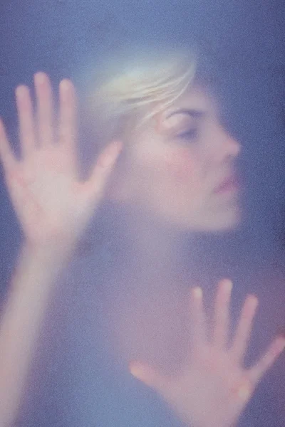 Blonde woman touching frosted glass — Stock Photo, Image